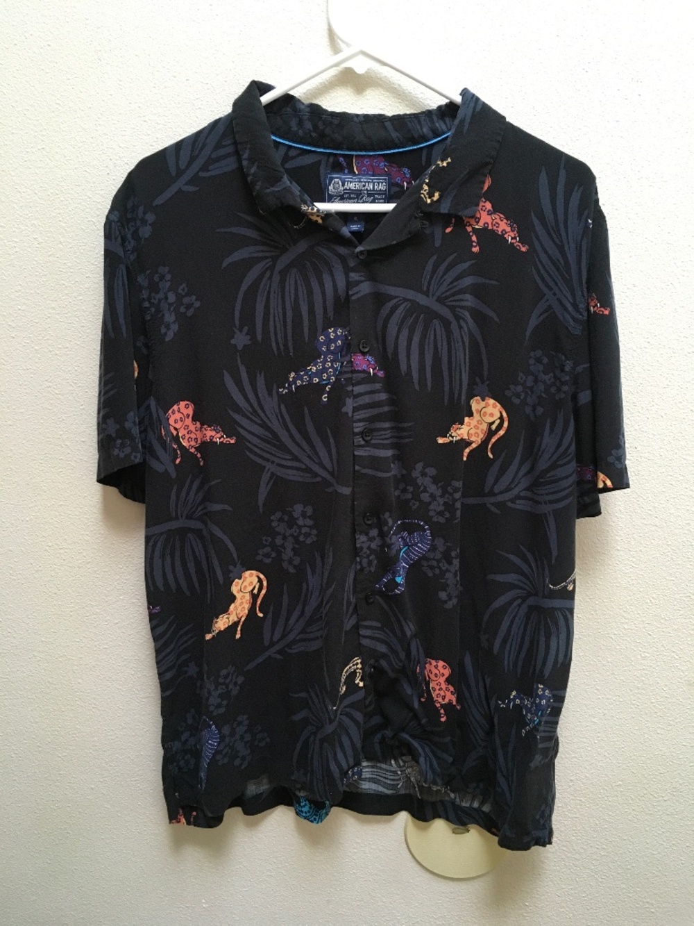American Rag adorable animal print blouse on black background.